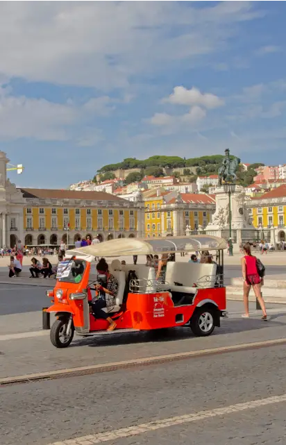 Tourists traveling in a Tuk-tuk in Lisbon