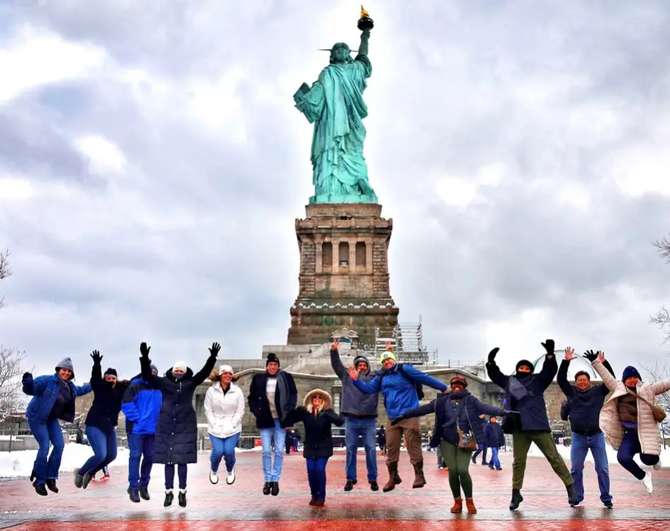 Visitors on Liberty Island Visitors posing behind the Liberty Statue